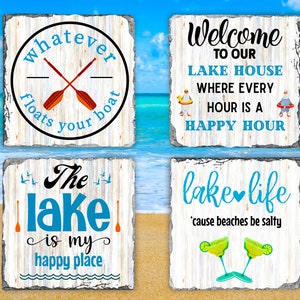 May include: Four wooden signs with whitewash paint and distressed lettering. The signs feature lake-themed sayings: "Whatever floats your boat", "Welcome to our lake house where every hour is a happy hour", "The lake is my happy place", and "Lake life 'cause beaches be salty".