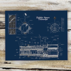 May include: A blueprint style illustration of the Hubble Space Telescope. The illustration shows the telescope's main body, solar panels, and other components. The text "Hubble Space Telescope" is printed in white on a dark blue background.