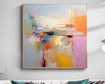 May include: Abstract art painting in a gold frame. The artwork displays a colourful composition of brushstrokes in shades of blue, orange, yellow, and pink. The painting hangs above a white sofa with green and zebra-print cushions.