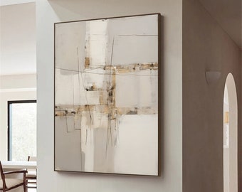 May include: Abstract painting in shades of beige, brown, and white with thin black lines. The painting is framed and hanging on a white wall in a modern living room. A white chair and a wooden stool are in the foreground.