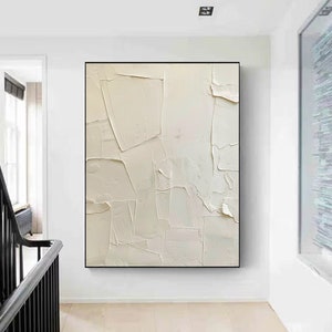 May include: Abstract painting with a white background and textured brushstrokes. The painting is framed in a black frame and is hanging on a white wall.