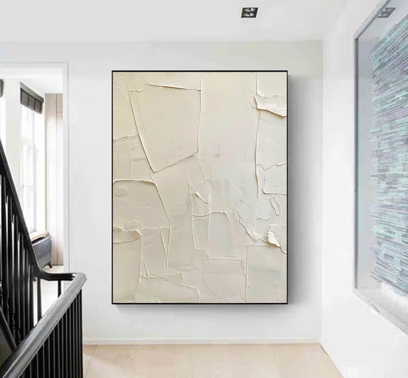 May include: Abstract painting with a white background and textured brushstrokes. The painting is framed in a black frame and is hanging on a white wall.