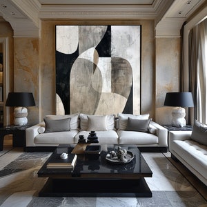 May include: A white sofa with gray pillows sits in front of a large abstract painting with black, white, and gray shapes. A black coffee table with a marble top sits in front of the sofa. Two black lamps with white bases are on either side of the sofa.