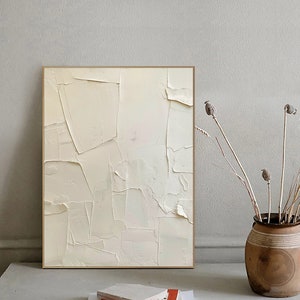 May include: Abstract painting with a textured, off-white background. The painting is framed in a thin, gold frame.