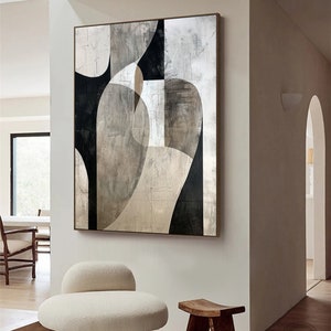 May include: Abstract art print with geometric shapes in black, white, and gray tones. The print is framed and hanging on a white wall in a modern interior.