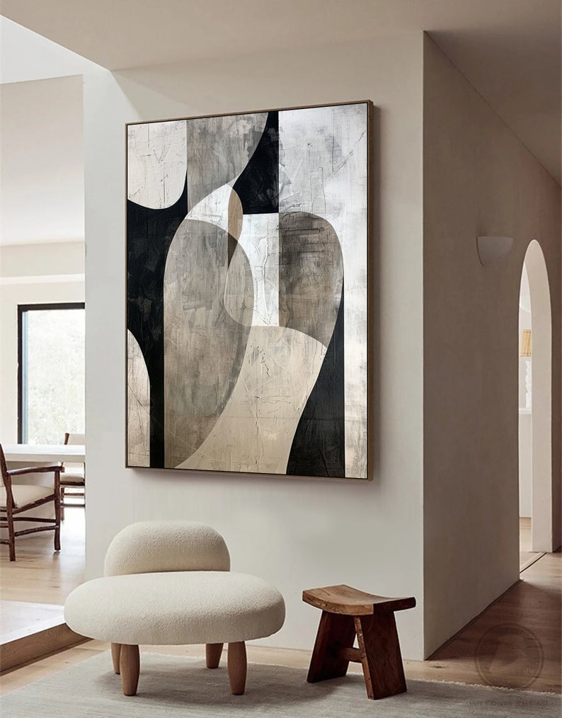 May include: Abstract art print with geometric shapes in black, white, and gray tones. The print is framed and hanging on a white wall in a modern interior.
