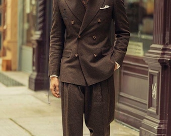 May include: A man's brown double-breasted suit with matching trousers and a fedora hat. The suit has a white pocket square and a patterned tie. The shoes are brown and tan. The logo for Swanky Suits is visible.