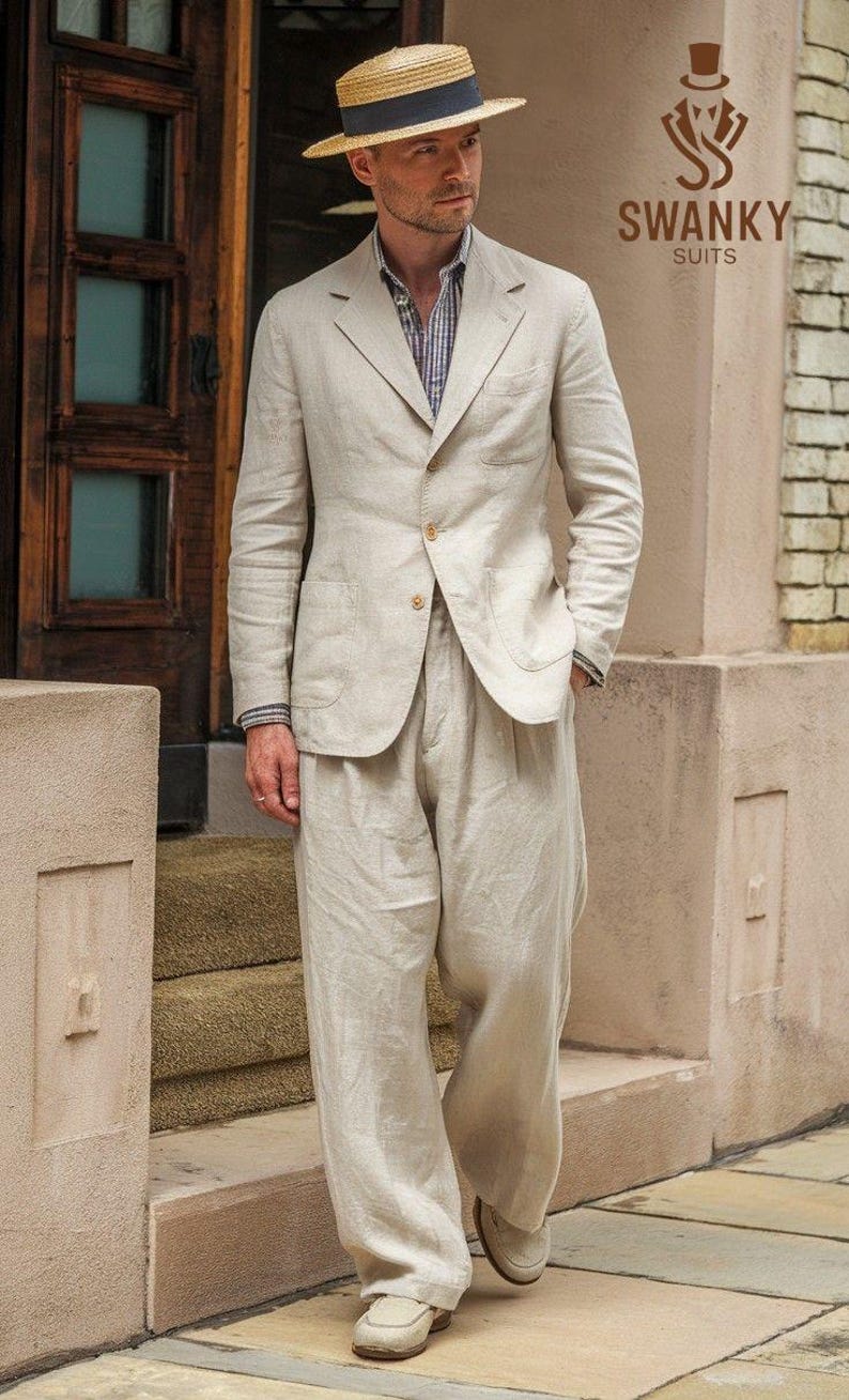 May include: A light beige linen suit with a straw boater hat. The suit includes a two-button blazer and wide-leg trousers. The hat has a navy blue band. The outfit is completed with beige loafers. The logo "SWANKY SUITS" is visible.