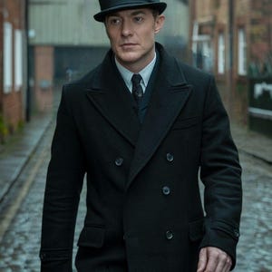 May include: A man wearing a black double-breasted overcoat and a black bowler hat. The coat has a classic design with large lapels and a double row of buttons. The image includes the "Swanky Suits" logo.