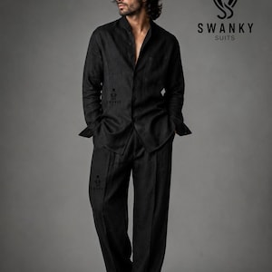 Peut inclure: Une chemise noire à manches longues boutonnée et un pantalon assorti à coupe ample. L'ensemble arbore le logo Swanky Suits, comprenant une icône de haut-de-forme et le texte SWANKY SUITS. Le tissu présente une texture visible et la chemise est ouverte.