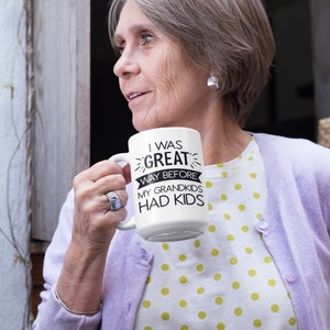 May include: White ceramic mug with black text that reads "I was great way before my grandkids had kids".