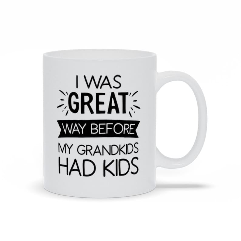 May include: White ceramic mug with black text that reads "I was great way before my grandkids had kids".