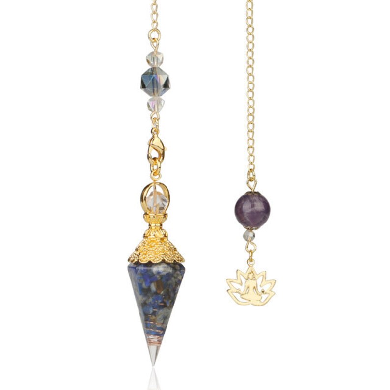 May include: Two pendulums with gold chains. One features a blue and gray crystal point with gold accents and clear beads. The other has a purple stone and a gold lotus charm. Both are designed for spiritual practices.