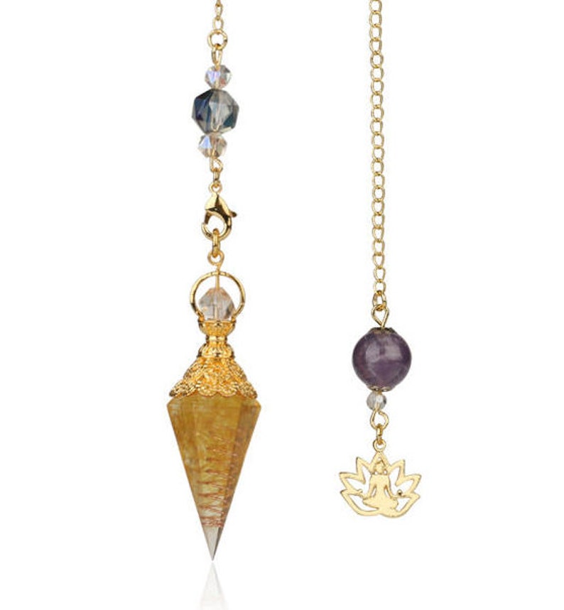 May include: Two pendulums with gold chains. One features a yellow crystal point with gold filigree and clear beads. The other has a purple sphere, clear beads, and a gold lotus charm. Both are designed for spiritual practices.