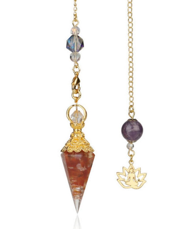 May include: Two pendulums with gold chains. One features a red and clear crystal point with gold accents and a clear crystal bead. The other has a purple sphere and a gold lotus flower charm.