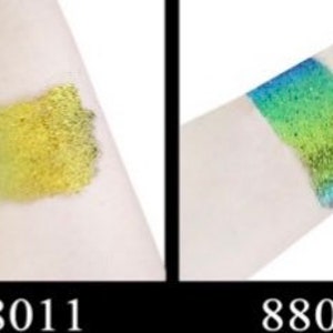 Op de afbeelding: Twee glitterstalen op de arm van een persoon. De linker staal is een gouden glitter en de rechter staal is een groen-blauwe glitter. De stalen zijn gemarkeerd met 88011 en 88012.