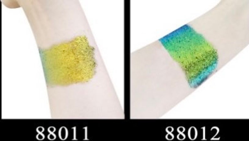 Op de afbeelding: Twee glitterstalen op de arm van een persoon. De linker staal is een gouden glitter en de rechter staal is een groen-blauwe glitter. De stalen zijn gemarkeerd met 88011 en 88012.
