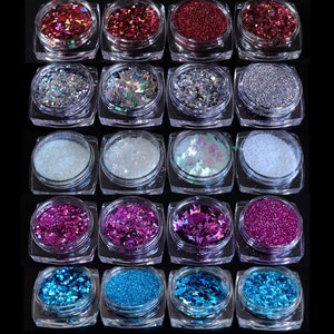 May include: Twenty-four small jars of glitter in various colours and shapes, including red, silver, white, pink, and blue. Some jars contain glitter in the shape of butterflies.