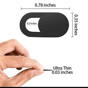 May include: Black webcam cover with a 0.78 inch by 0.35 inch oval shape. The cover is 0.03 inches thick and has a small hole in the center.