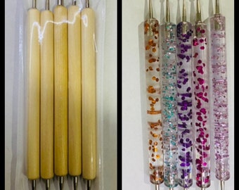 May include: Set of six nail art tools. Five tools have wooden handles and one tool has a clear handle with glitter and colorful flecks. The tools have different shaped tips for nail art.