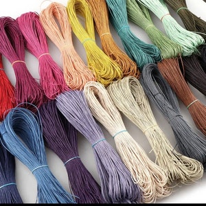 May include: Assortment of colorful waxed cotton cords, perfect for crafting and jewelry making. The cords are arranged in a rainbow pattern, with colors including red, orange, yellow, green, blue, purple, brown, and white.