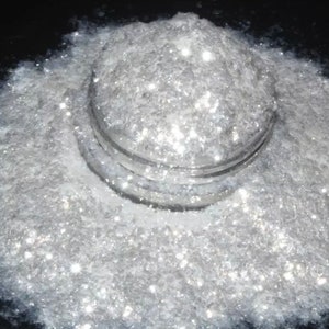 Puede incluir: Un montón de purpurina blanca iridiscente, ideal para manualidades y añadir brillo a los proyectos.