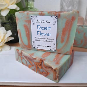 May include: Two bars of handmade shea and cocoa butter soap, called "Desert Flower", with a green and orange swirl pattern. The soap is handmade in Minnesota and weighs approximately 4.4 ounces.
