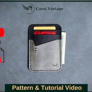 Op de afbeelding: Een grijs leren portemonnee met een zwarte leren klep en een klein vak voor contant geld. De portemonnee heeft een gestikte rand en een logo met de tekst "Cassi Vintage".