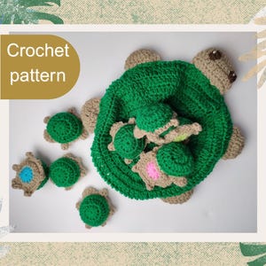 Op de afbeelding: Een groene en beige gehaakte schildpad met verschillende kleinere schildpadden. De grote schildpad heeft een groen schild en een beige kop en poten. De kleinere schildpadden zijn groen en beige. De tekst "Crochet pattern" staat linksboven.