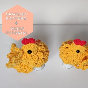 Może przedstawiać: Dwa żółte kurczaki wykonane na szydełku z czerwonymi grzebieniami, siedzące na białych podstawach. Obraz zawiera tekst "CROCHET PATTERN + VIDEO TUTORIAL".