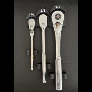 May include: Three silver ratcheting wrenches with black handles and white labels. The labels read "1/4", "3/8", and "1/2".