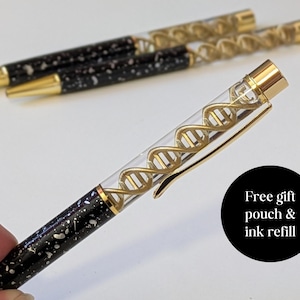 May include: Ballpoint pens with a DNA helix design. The pens have gold accents and a black barrel speckled with white. The image includes the text "Free gift pouch & ink refill".