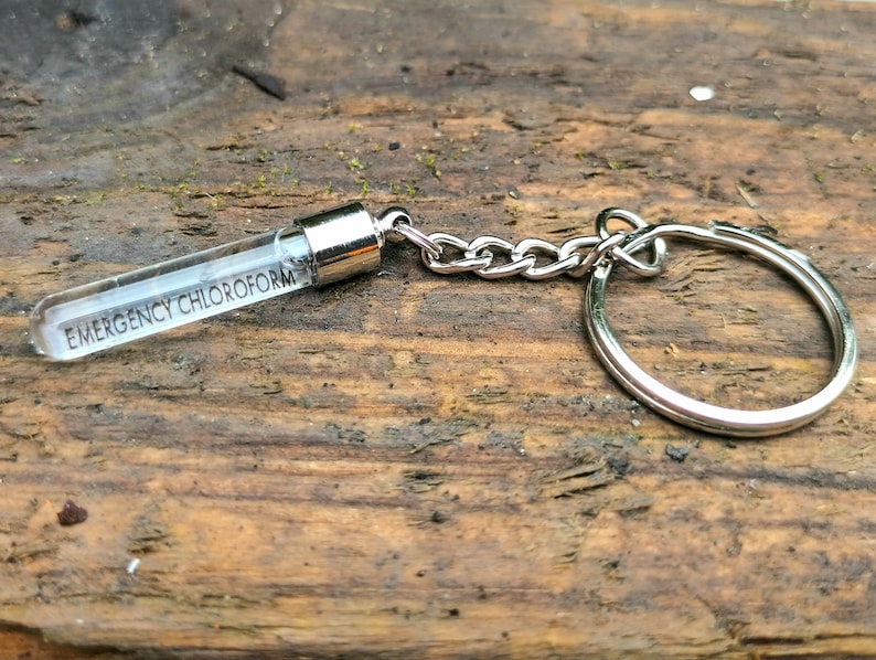 May include: A silver keychain with a clear glass vial that says "EMERGENCY CHLOROFORM" on it.