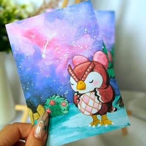 Könnte beinhalten: Ein rechteckiger Kunstdruck mit einer Aquarellillustration einer braunen Eulenfigur mit rosa Schleifen, die auf einer blauen Fläche steht. Der Hintergrund zeigt einen leuchtend violetten und blauen Nachthimmel mit weißen Sternen.