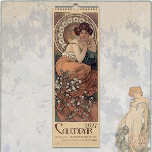 May include: A 2027 wall calendar featuring an Art Nouveau illustration by Alphonse Mucha. The central image depicts a person in a flowing peach-coloured garment surrounded by botanical elements and a circular decorative frame. Text includes 2027 CALENDAR.