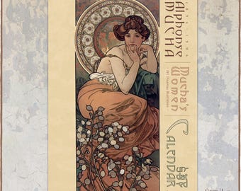 May include: A wall calendar featuring an Alphonse Mucha illustration of a person with reddish-brown hair in a flowing peach-coloured garment. The design includes a circular decorative background, botanical elements, and text reading Mucha's Women Calendar.