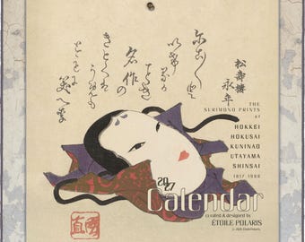 May include: A 2027 wall calendar featuring a traditional Japanese mask illustration with black hair and red lips. The design includes Japanese calligraphy, the text The Surimono Prints of Hokkei Hokusai Kuninao Utayama Shinsai, and Etoile Polaris.