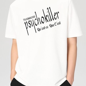 May include: White t-shirt with the text "psychokiller" in a stylized black font, with the phrase "Qu'est-ce Que C'est" below. The shirt also has the word "TVLKINGHEVDS" above the word "psychokiller".