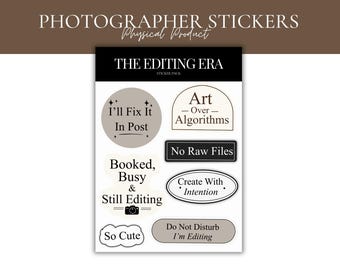 May include: A sticker sheet with the text "PHOTOGRAPHER STICKERS" and "Physical Product" at the top. The sheet features various stickers with phrases like "I'll Fix It In Post", "Art Over Algorithms", and "No Raw Files". The stickers are in neutral colors.