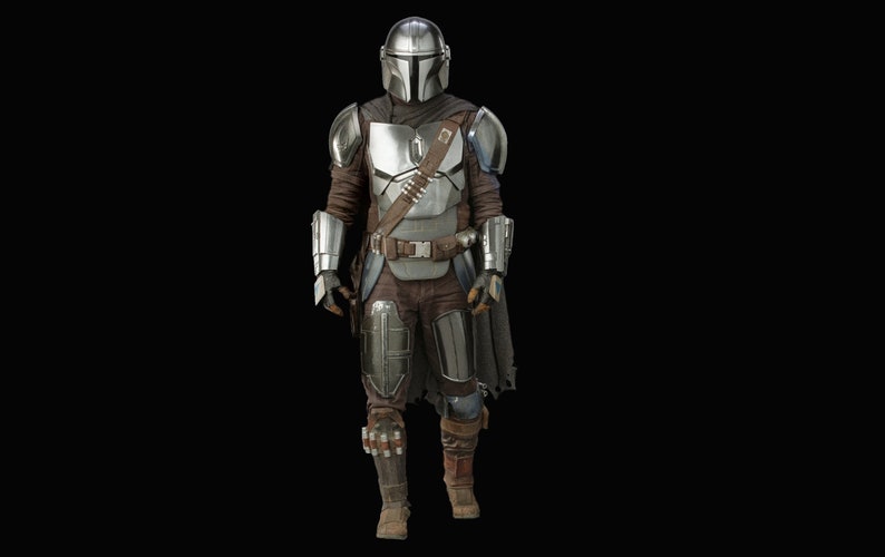 May include: A silver and brown Mandalorian costume with a helmet and a cape. The costume is worn by a person standing in front of a black background.