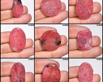 May include: Nine pink and black gemstone cabochons of various shapes and sizes, including oval, round, and teardrop. The stones have a translucent appearance with a mix of pink and black colors.