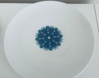 May include: White ceramic plate with a blue and green floral design in the center.