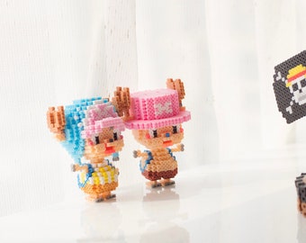 May include: Two small, colorful, pixelated figures of a popular anime character, with a black and white pirate flag in the background.