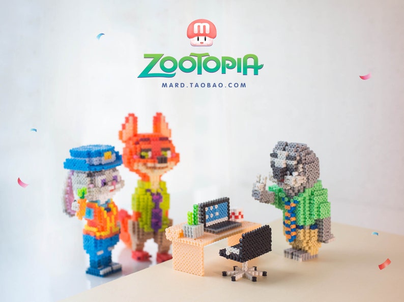 May include: A set of three Zootopia character figurines made of colorful plastic beads. The characters are Judy Hopps, Nick Wilde, and Flash. The figurines are standing in front of a small desk with a computer and chair. The text "Zootopia" and "mard.taobao.com" is visible in the background.