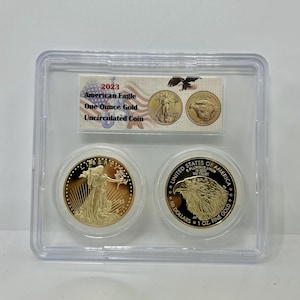 Könnte beinhalten: Eine ungezirkelt 2023 American Eagle Ein-Unzen-Goldmünze in einem durchsichtigen Plastiketui. Die Münze zeigt auf der einen Seite eine Darstellung von Lady Liberty und auf der anderen Seite einen Adler. Die Münze befindet sich in einem Schutzetui mit einem Etikett mit der Aufschrift "2023 American Eagle One Ounce Gold Uncirculated Coin."