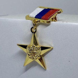 以下が含まれることがあります： 中央に双頭の鷲が描かれた金の星が、小さなロシアの国旗からぶら下がっている