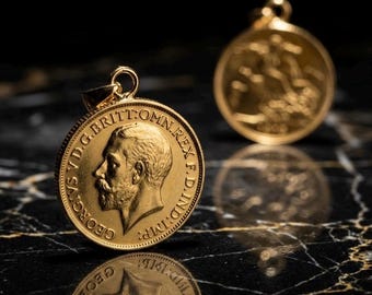 Könnte beinhalten: Zwei goldene Münzanhänger mit aufwendigen Details. Einer zeigt das Profil eines Mannes mit Text. Der andere zeigt ein Design auf der Rückseite. Beide sind an kleinen Goldschleifen aufgehängt.
