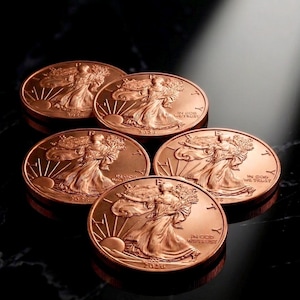 Może przedstawiać: Pięć monet w kolorze miedzi z szczegółowym reliefem kobiety trzymającej gałązkę, z napisem "IN GOD WE TRUST" i rokiem 2020. Monety ułożone są na ciemnej, odbijającej światło powierzchni.