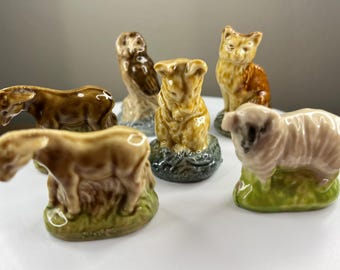 以下が含まれることがあります： さまざまな動物を描いた、6体のミニチュアセラミック製フィギュアのセット。茶色のロバ、茶色と白の羊、茶色と白の牛、茶色のフクロウ、茶色と白の猫、茶色と白の豚など。フィギュアはすべて白い表面に立っています。