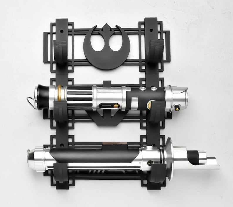 May include: Black wall mount with a Rebel Alliance symbol and two slots for lightsabers. The lightsabers are silver and black with gold accents.